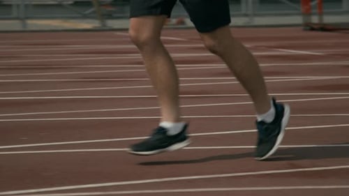 Legs of Unrecognizable Athlete Running on Track at Stadium