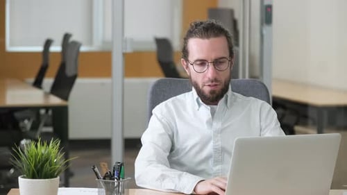 Satisfied Businessman Sitting in Modern Office