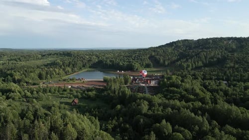 Stunning Aerial View Showcasing a Lush Green Forest Surrounded By a Tranquil Water Body Clip