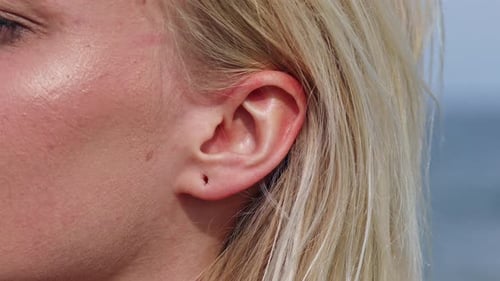 Close up shot of wound hole in ear lobe of blonde woman,macro view