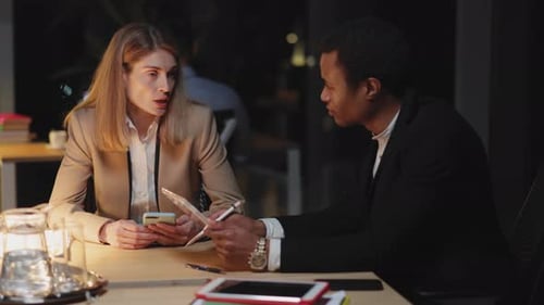 Couple of Office Manager and Businesswoman Discussing Business Plans for Future Sitting in Dark