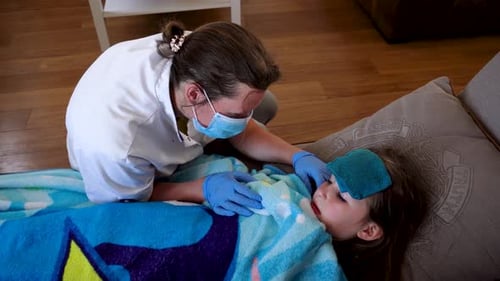Home care nurse treating child at home, reassuring the child and making her smile