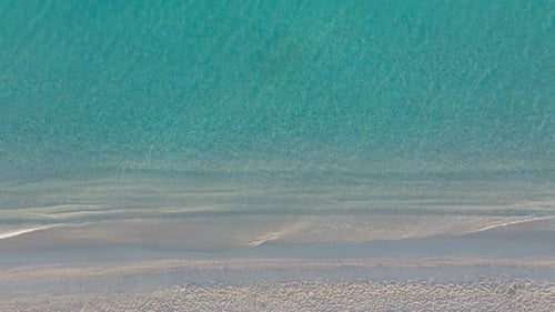 Aerial Topdown View of Sparkling Sea Textures at the Beach