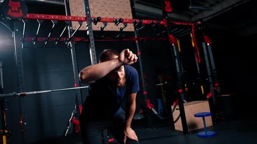 portrait of a tired athlete in the gym after training a man wipes sweat from his forehead with hand