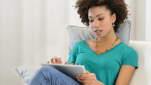 Young Woman Relaxing at Home Using Tablet