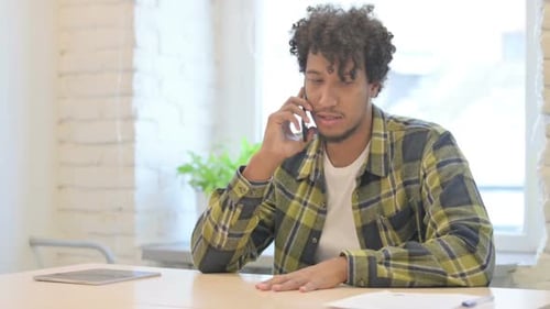 African Man Talking on Phone in Office