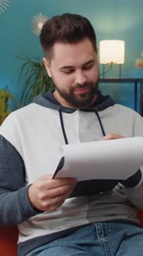 Young man reviewing documents at home