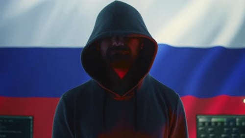 Man Holds Skull in Front of Flag and Computers