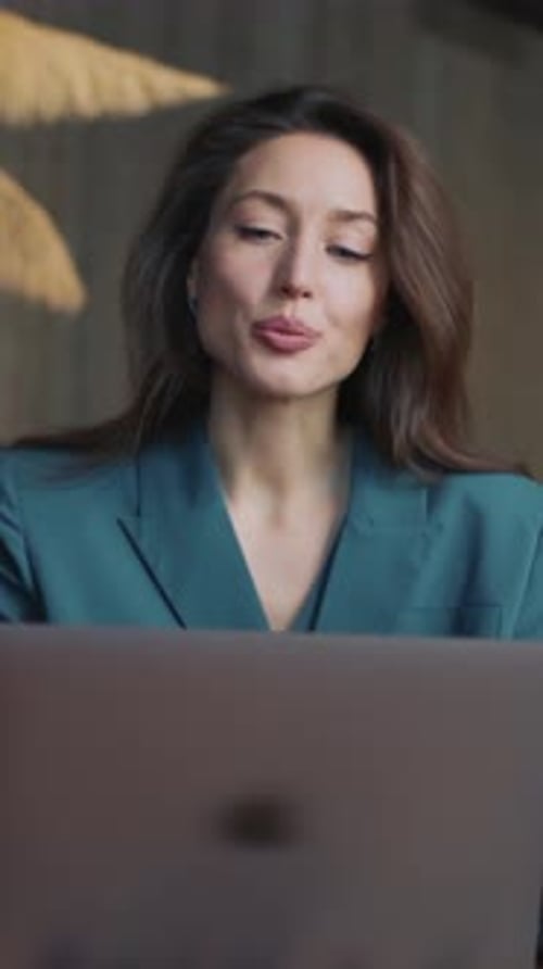 Businesswoman in Teal Blazer Using Laptop on Video Call