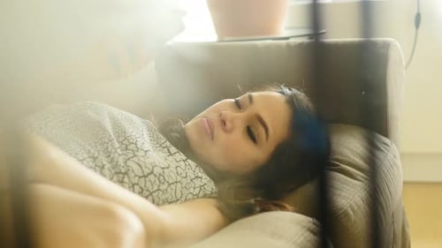 Woman Relaxing with Cell Phone on Couch