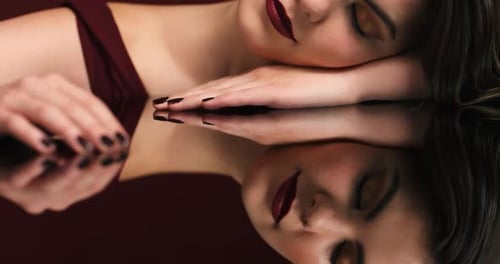 Glamorous Woman Relaxing, Reflected in Shiny Surface