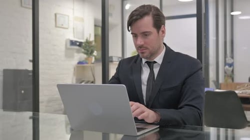 Man Working on Laptop in Modern Office