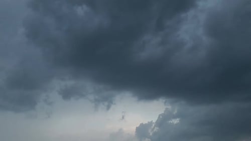 Dramatic dark storm clouds fill the sky, creating a moody, overcast atmosphere with varying shades o