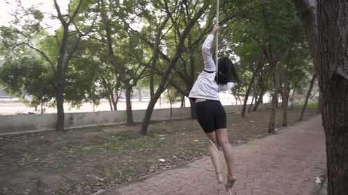 A sporty gymnast performs exercises with a rope in sportswear.Concept: power, strength, healthy life