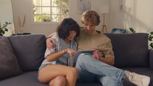 Couple Relaxing with Tablet in Living Room