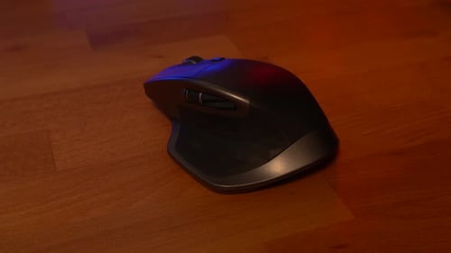 Mouse on wooden desk with red and blue reflections