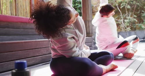 Mixed race couple performing stretching exercise together at vacation home