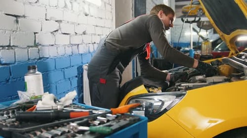 Mécanicien en entretien automobile, réparation dans le compartiment moteur