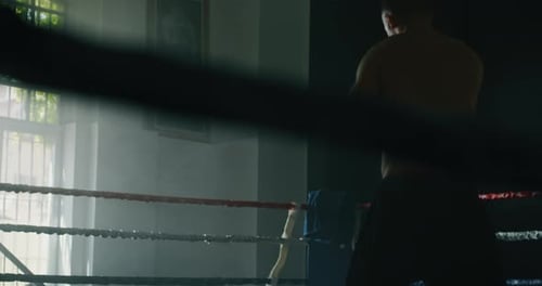 Cinematic slow motion close up shot of two professional young muscular shirtless male boxers are f