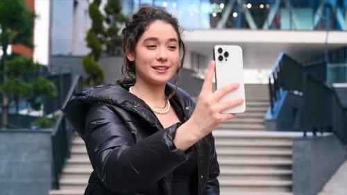 Young Woman Video Calling on Cell Phone Outdoors