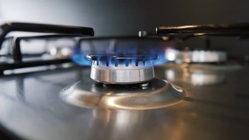 Nahaufnahme der Flamme des Gasbrenners auf einer modernen Herdplatte