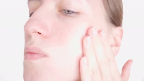 Woman Applying Cream on Face Close-Up