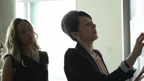 Businesswomen brainstorming strategy in office meeting with teamwork and dedication