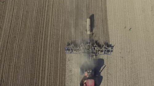 Big red tractor working on the field cultivating and applying nitrogen ASP