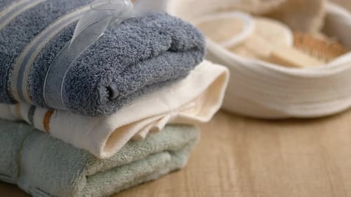 Relaxing Spa Setup with Soft Towels and Accessories on Wooden Table