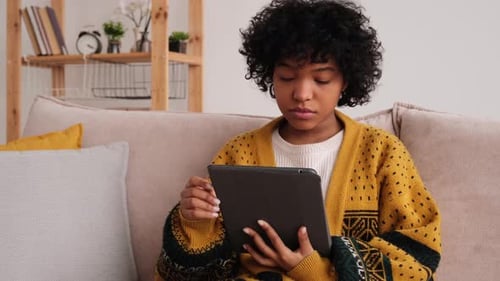 Young Woman Using Tablet Device on Couch
