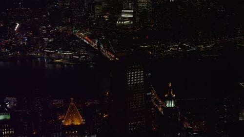 Manhattan bridge and brooklyn bridge glow over east river New York City winter night