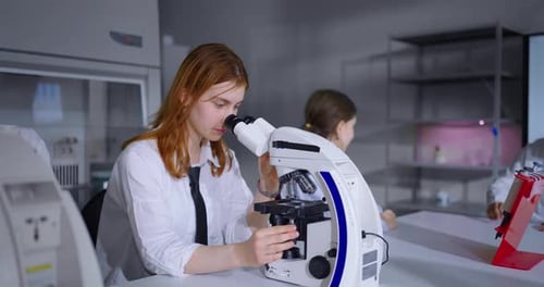 School Students Studying Biology Teenagers Looking At Microscopes In Modern Classroom