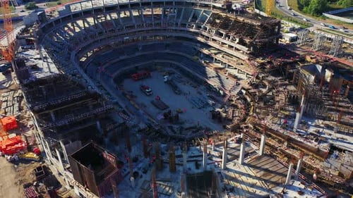 Las grúas construyen los cimientos de concreto de un estadio contemporáneo