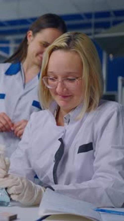 Two Women Work Together in a Bright Lab
