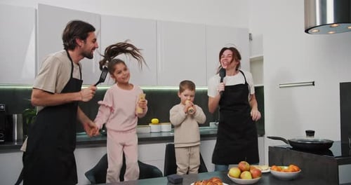 Family Singing and Dancing Together in Kitchen