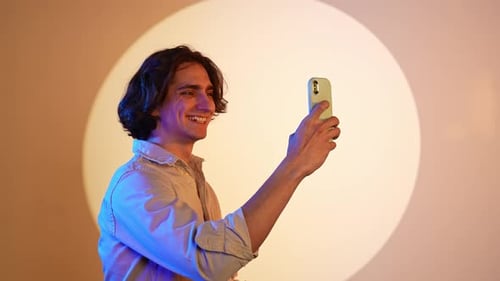 Happy Young Man Taking Selfie with Phone Indoors