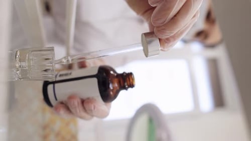 Scientist Filling Glass Dropper with Solution