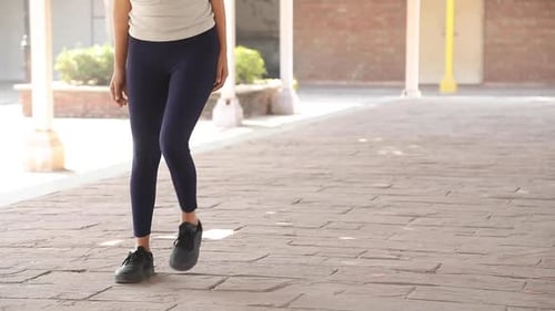 Woman Exercising Legs Outdoors in Urban Setting