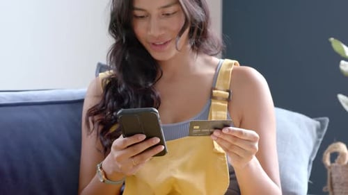 Woman Shops Online with Phone and Credit Card