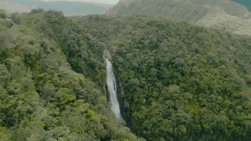 4k Aerial big waterfall in forest Drone dolly in + tilt down shot