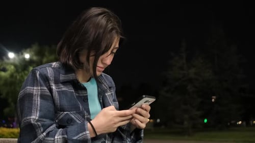 Young Adult Using Cellphone at Night
