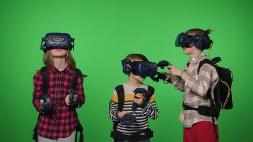 A Group of Children Wearing Virtual Reality Glasses in a Studio with Chroma Key