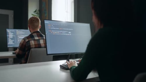 Data Scientist and Data Analyst Working in Office View Through Shoulder Male and Female Specialists