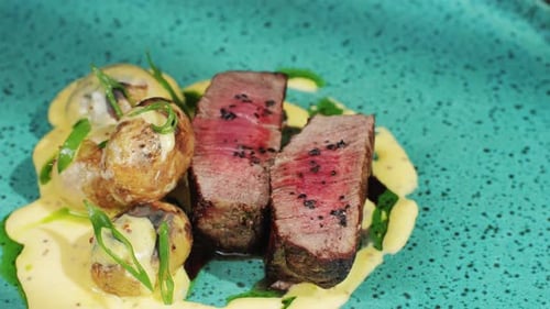 Juicy Medium Beef Meat Rib Eye Steak Slices with Baked Potato in Expensive Modern Fusion Restaurant