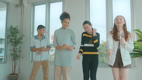 Gruppe glücklicher Schüler tanzt im Klassenzimmer