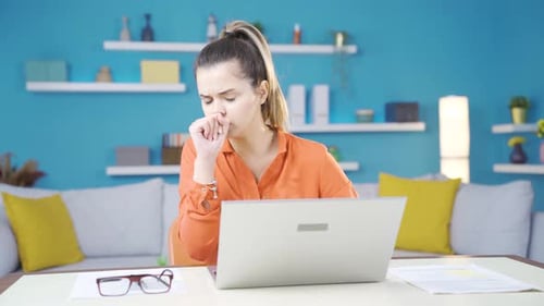 Sick young business woman working in her home office.