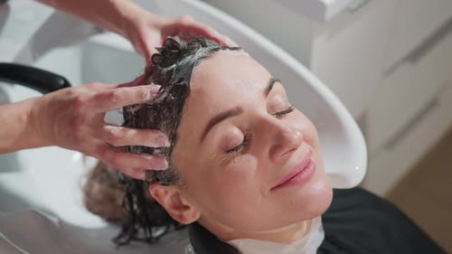 Woman Enjoying Soothing Hair Wash with Relaxed Expression Comfortable Salon Scene with Woman