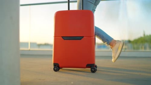 Woman Confidently Pulling a Suitcase in an Airport Terminal Side View Slow