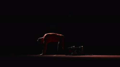 Athlete Prepares in Starting Blocks in the Dark