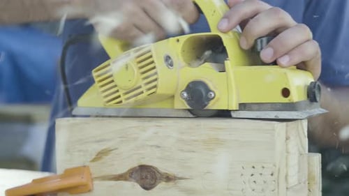 Close up shot of power tool electric plane working on a wood post